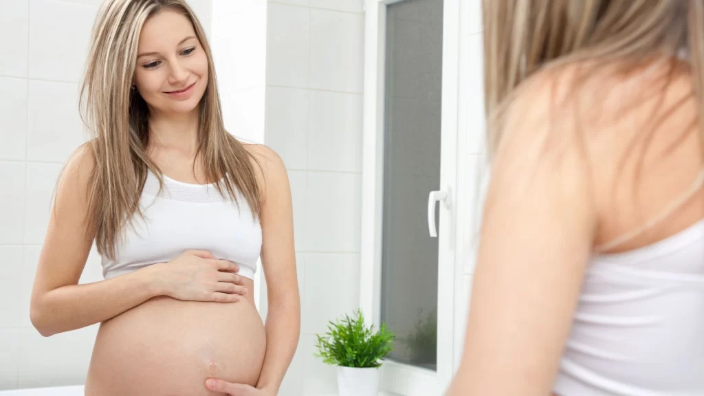 Pregnant surrogate holding her belly, representing the benefits of being a surrogate in California