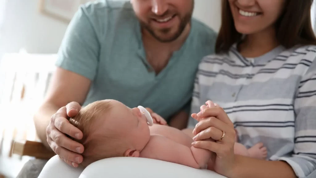 Intended parents holding a newborn baby through surrogacy in California
