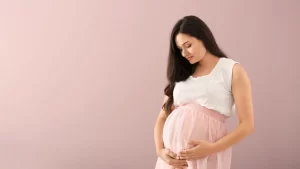 Woman gently holding her pregnant belly during a surrogate pregnancy in California