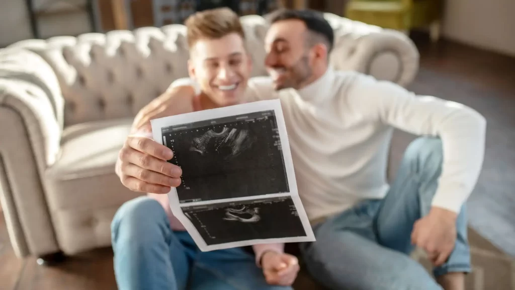 Gay couple reviewing ultrasound during surrogacy journey in California