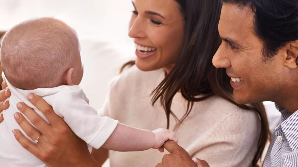 International intended parents holding newborn after surrogacy in California