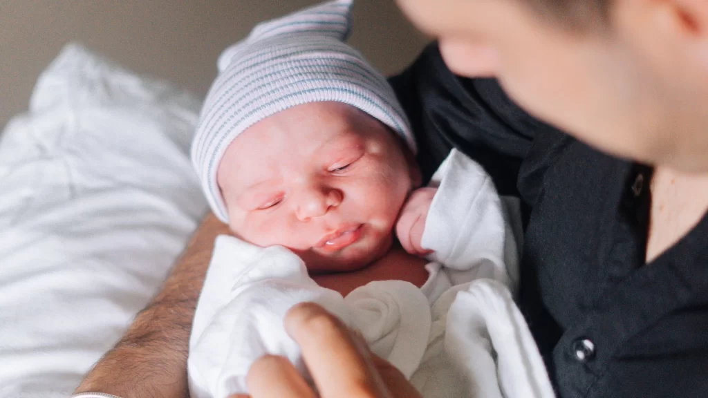 Newborn baby being cared for during surrogacy journey with single father